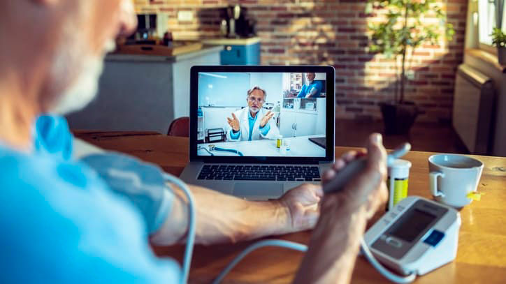 A man is using a laptop to monitor his blood pressure.