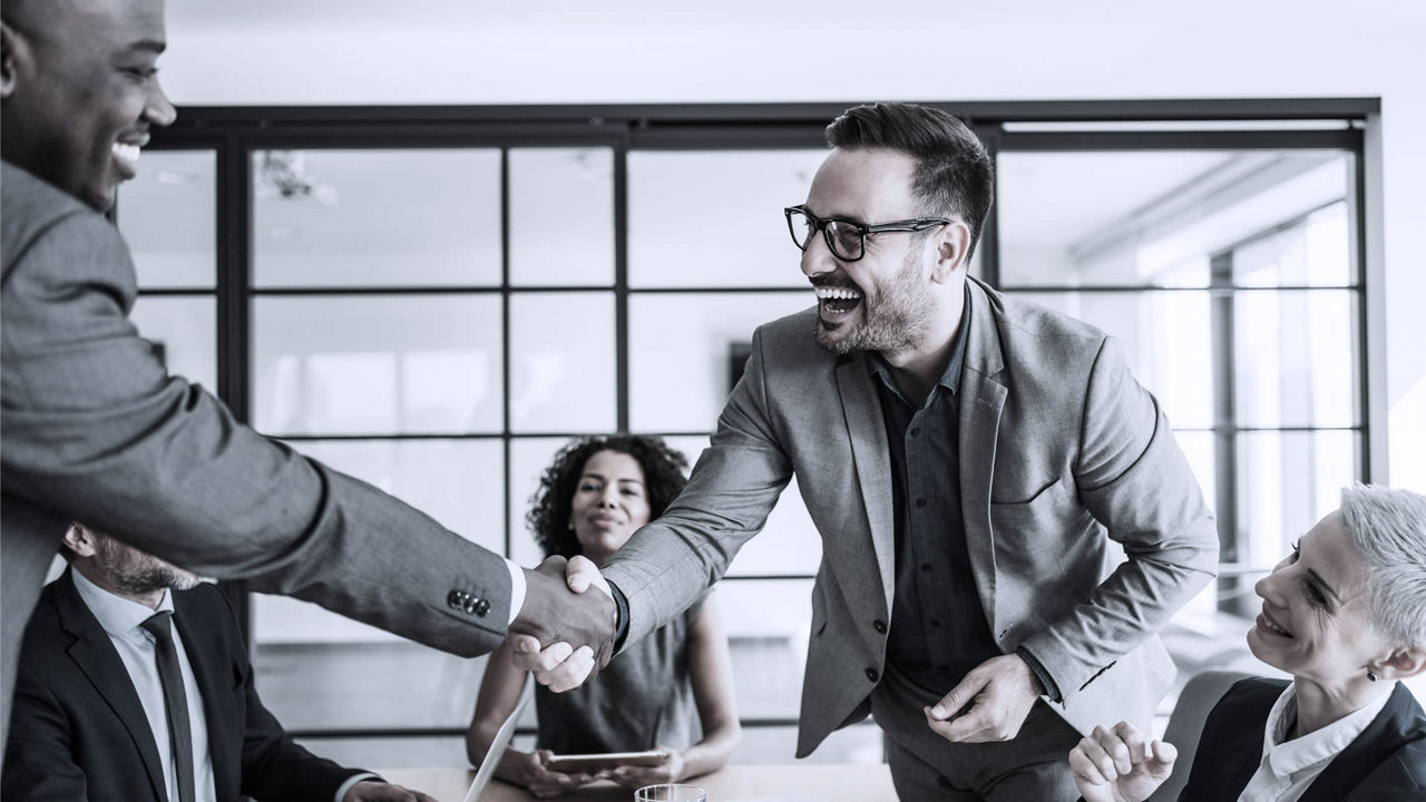 A group of business people shaking hands in an office.