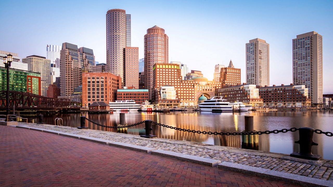 The Boston Harbor and Financial district in Boston at sunrise showcasing its mix of contemporary and historic buildings.