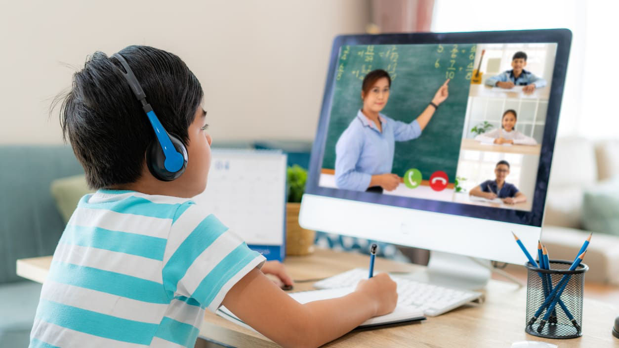 A young boy is using a computer to watch a video.