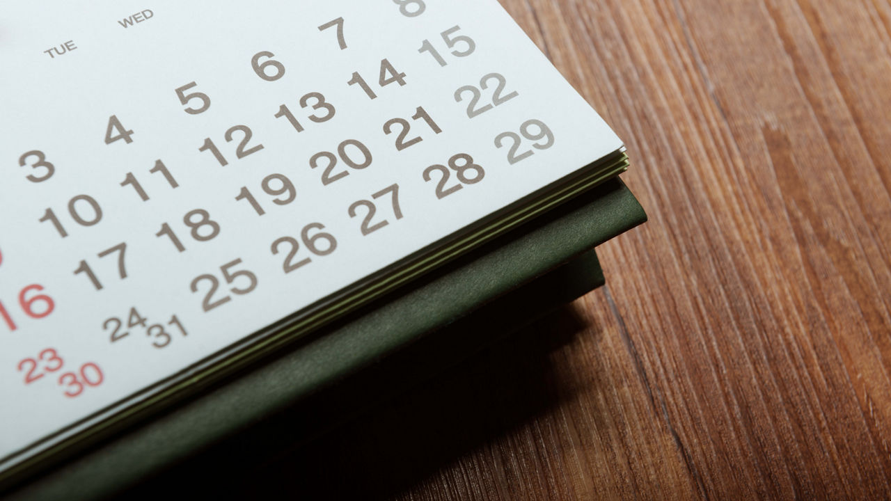 A calendar sitting on top of a wooden table.