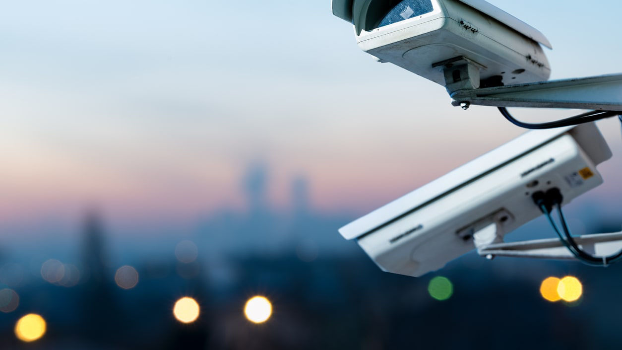 Two cctv cameras on top of a building.