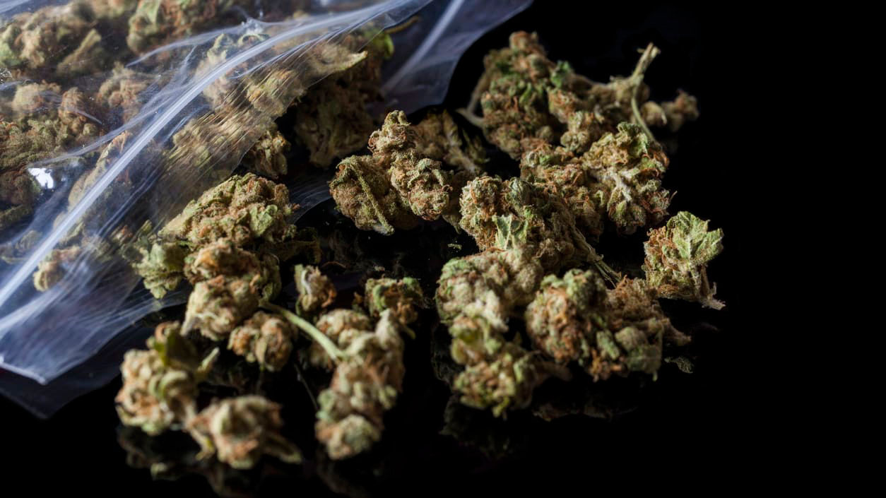 Marijuana in a plastic bag on a black background.