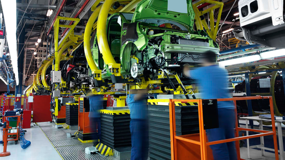 Workers working on a car assembly line in a factory.