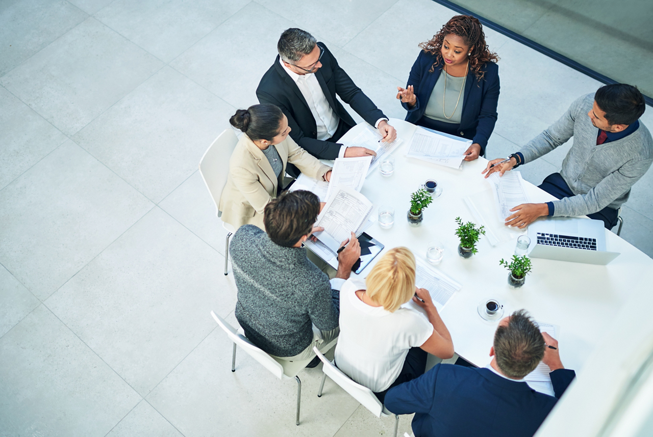 Meeting, documents and business people in top view office planning, strategy and startup sales profit review. Economy, problem solving and accounting team brainstorming inflation, solution and ideas