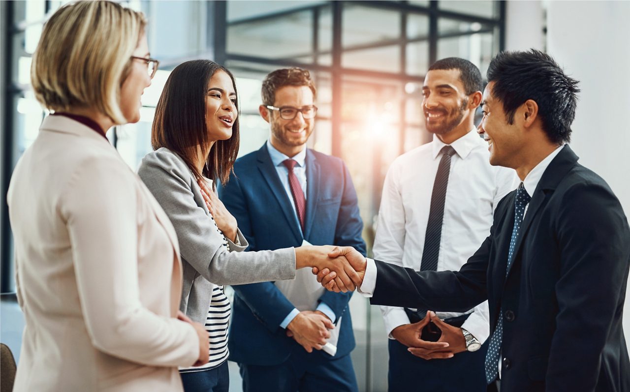 workplace professionals in a circle shaking hands