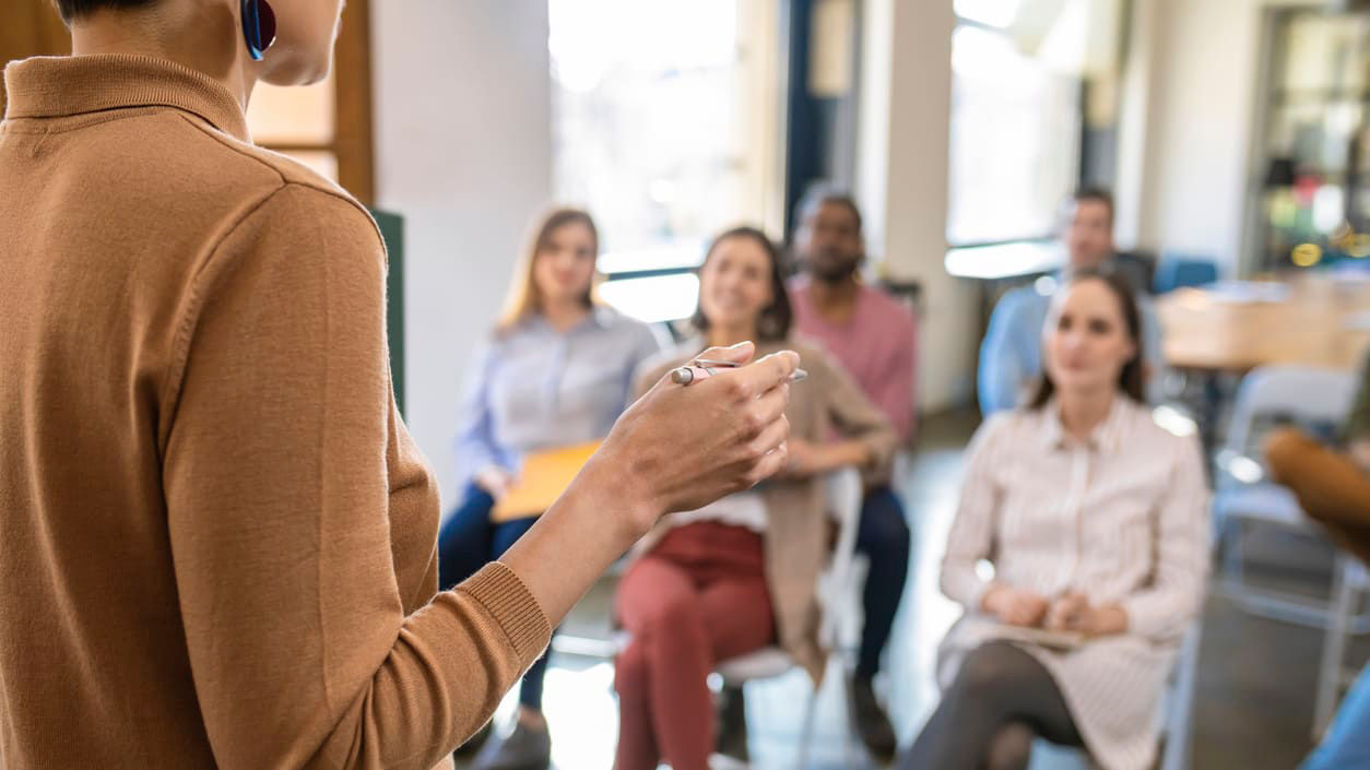 A woman giving a presentation to a group of people.