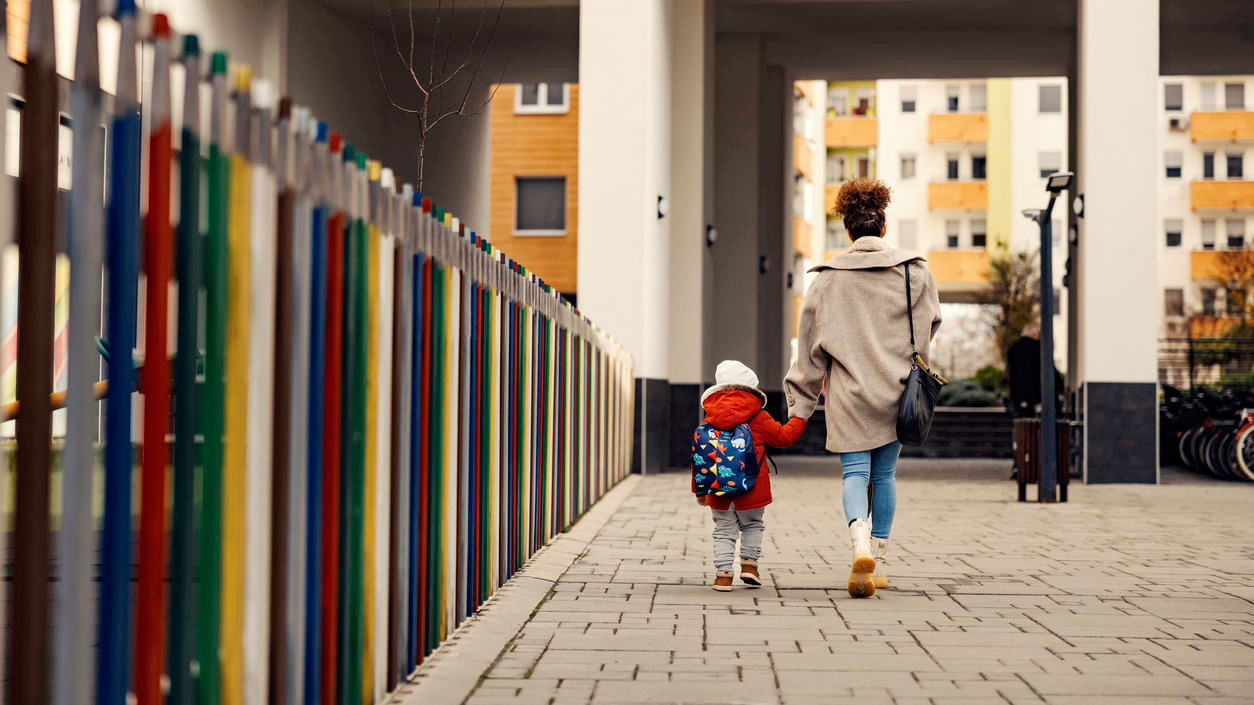 A woman and a child walking down a sidewalk.