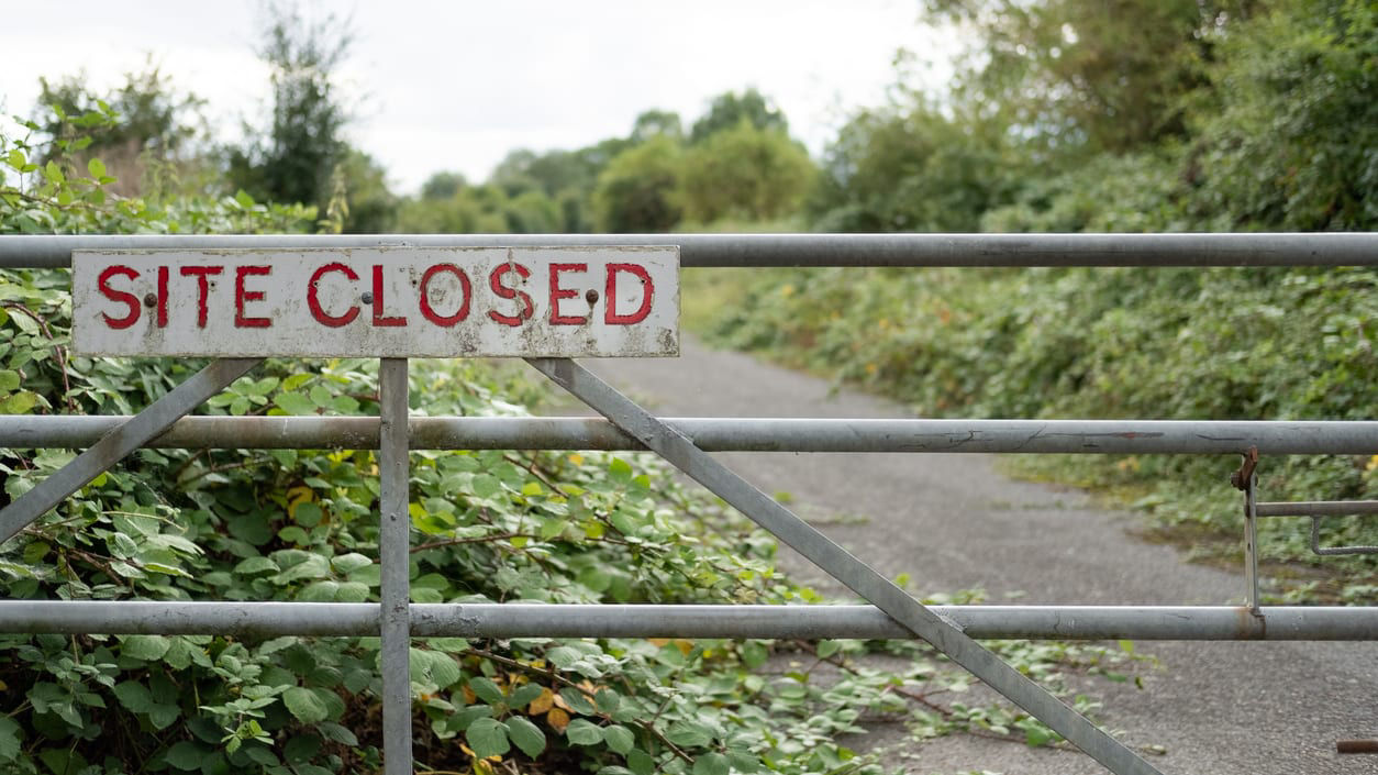 A metal gate with a sign that says site closed.