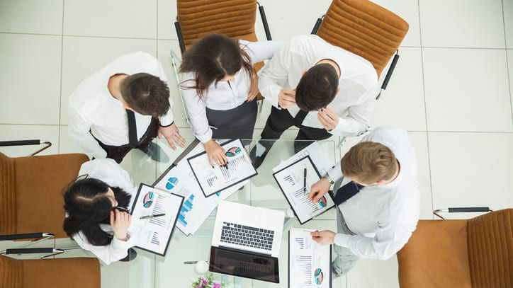 A group of business people sitting around a table.