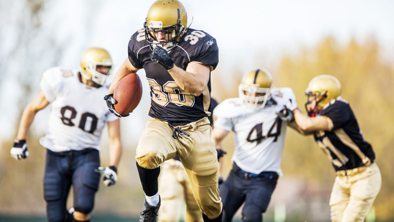 A group of football players running with the ball.
