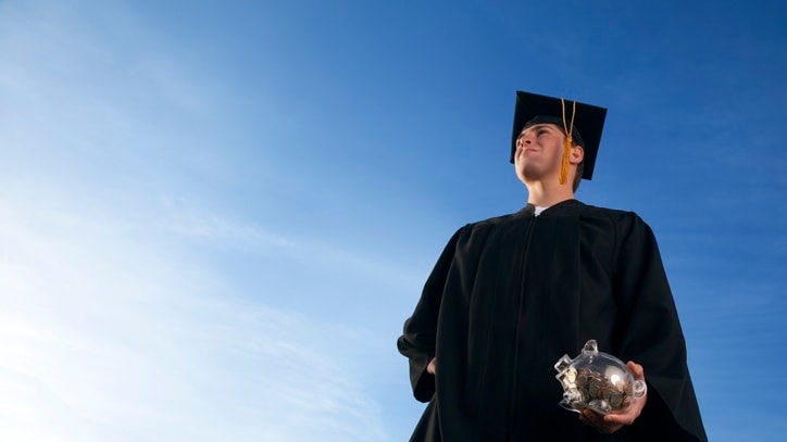 A young man in a graduation gown holding a graduation ball.