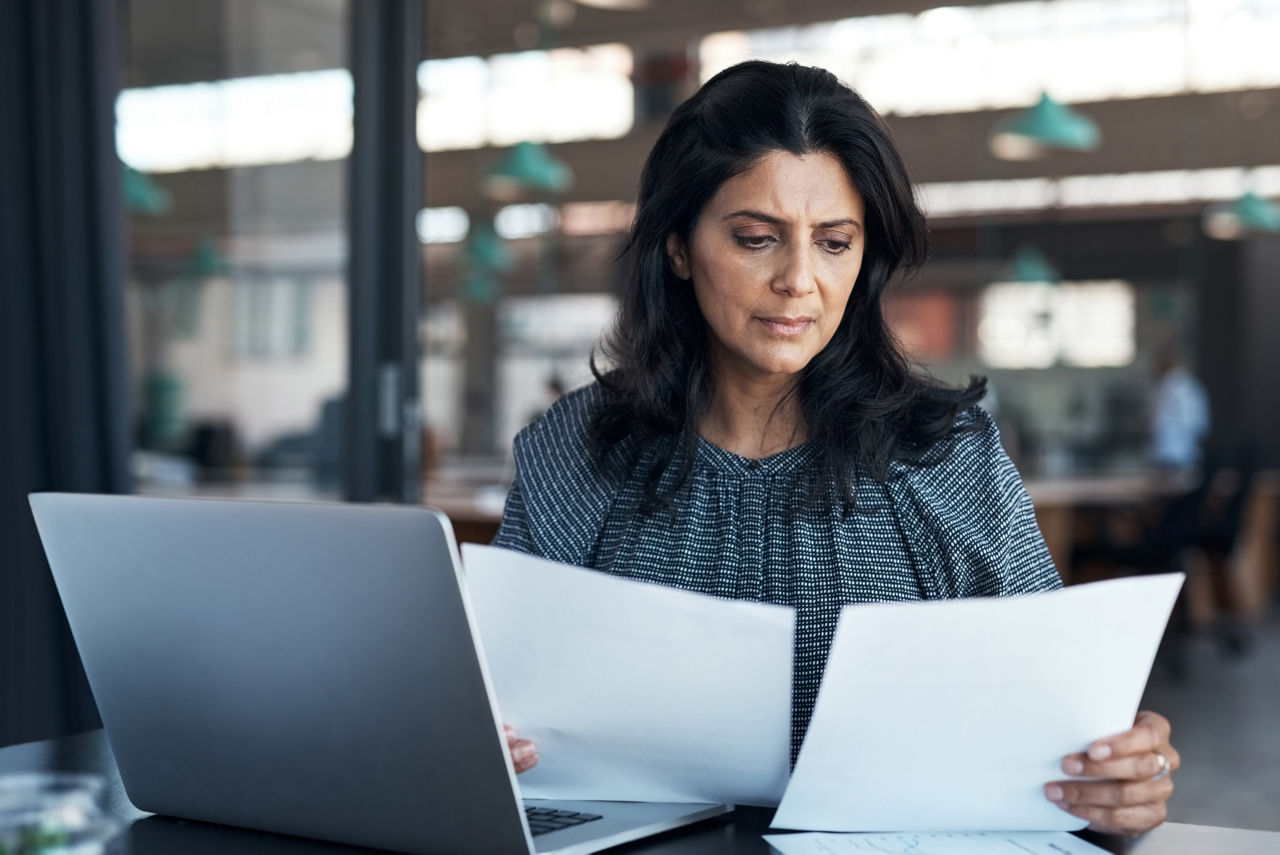 A woman looks at paperwork.