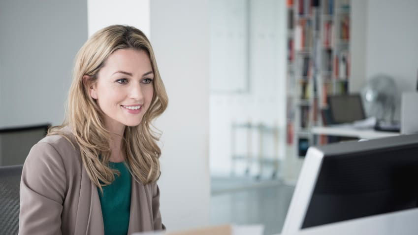 A woman sitting in front of a computer in an office.