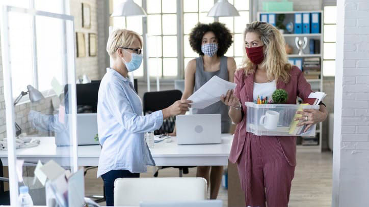 Two women wearing face masks in an office.