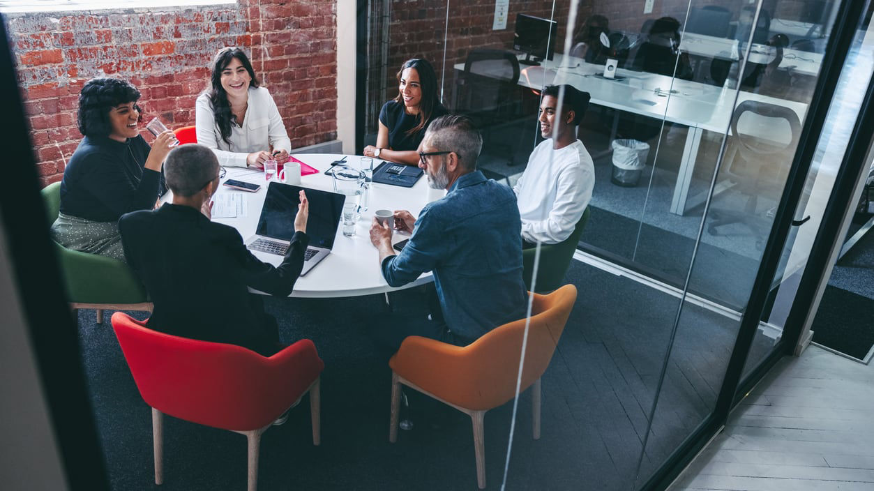 A group of people sitting around a table in a conference room.
