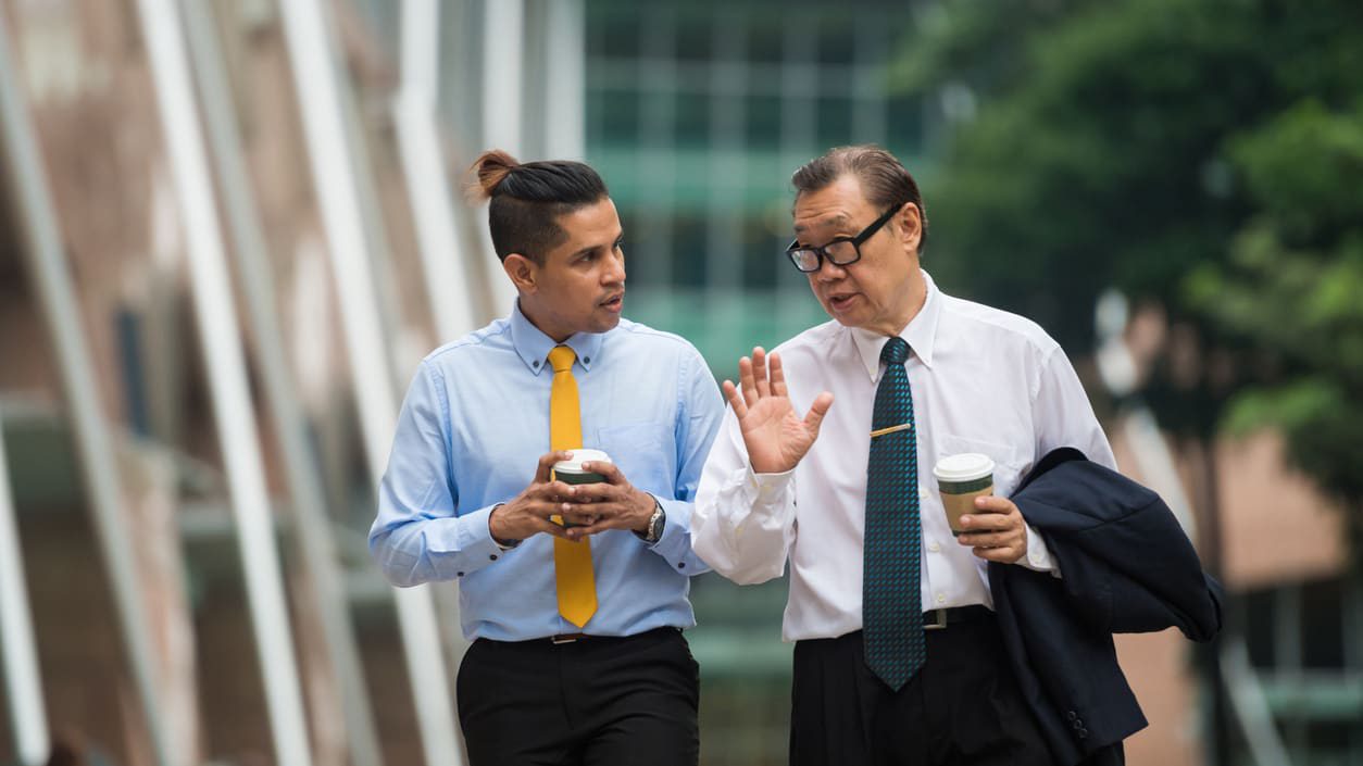 Two men in business suits walking down the street.