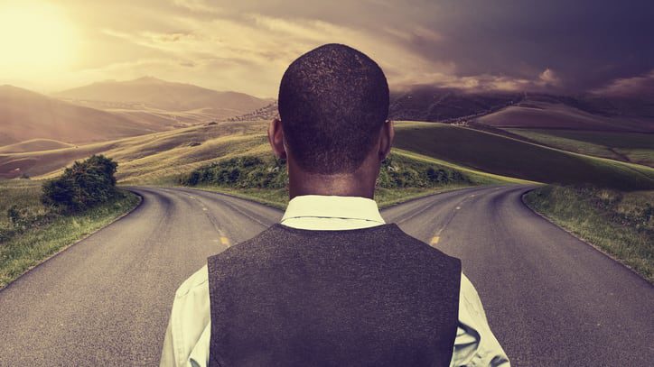 A man is standing on an empty road.