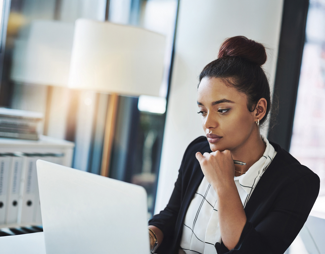 Shot of a young businesswoman using a laptop in a modern office