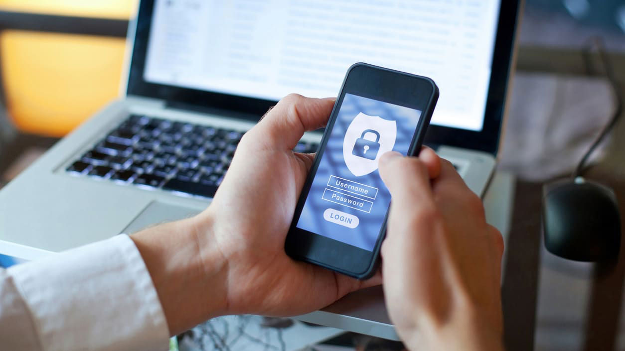 A person holding a smartphone with a lock screen on it.