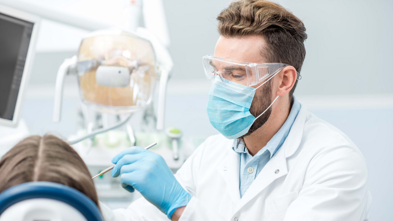 A dentist is examining a patient's teeth.