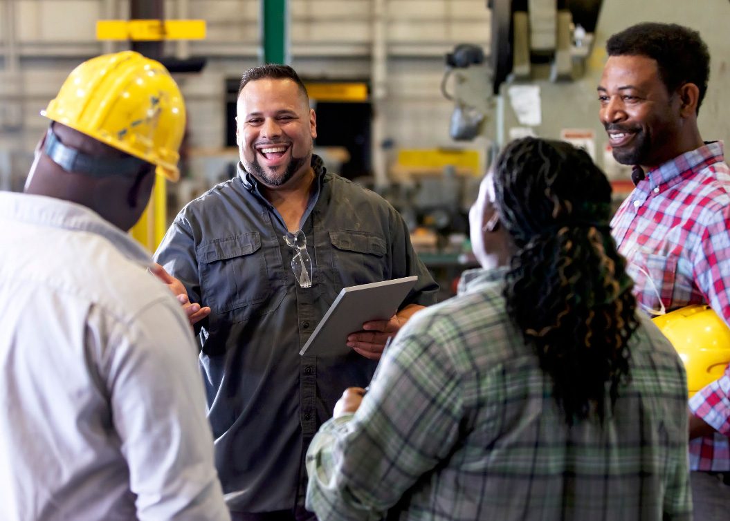 Factory workers talking with one another.