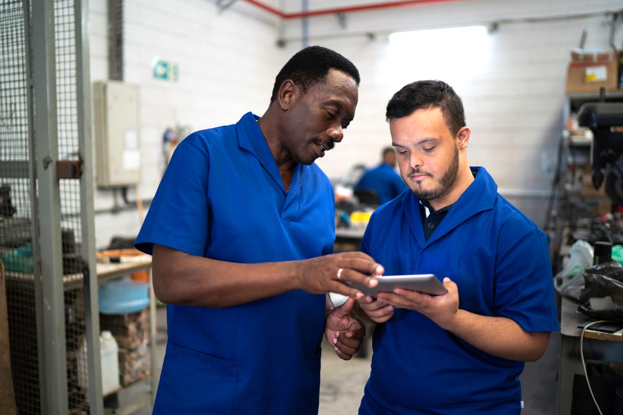 Colleagues using digital tablet and working in industry