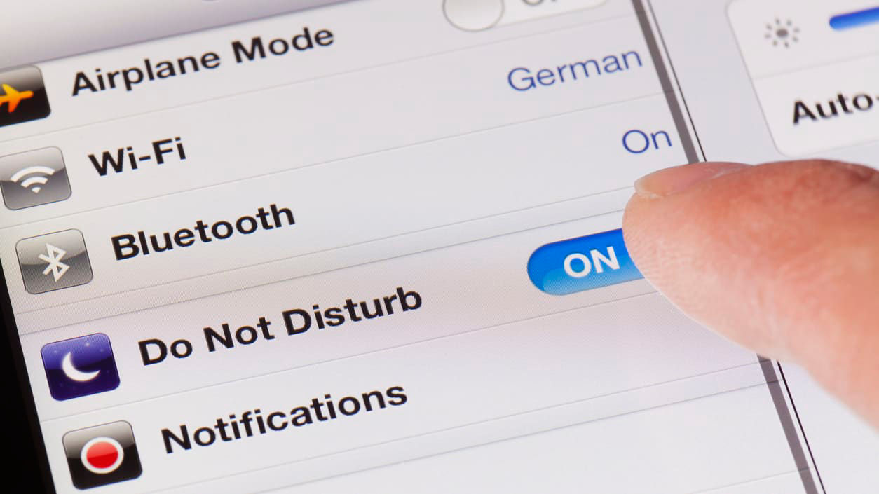 A person pointing at an ipad with an airplane mode on it.