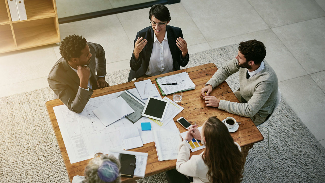 A group of business people sitting around a table.