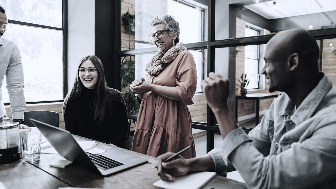 A group of people sitting around a table in an office.