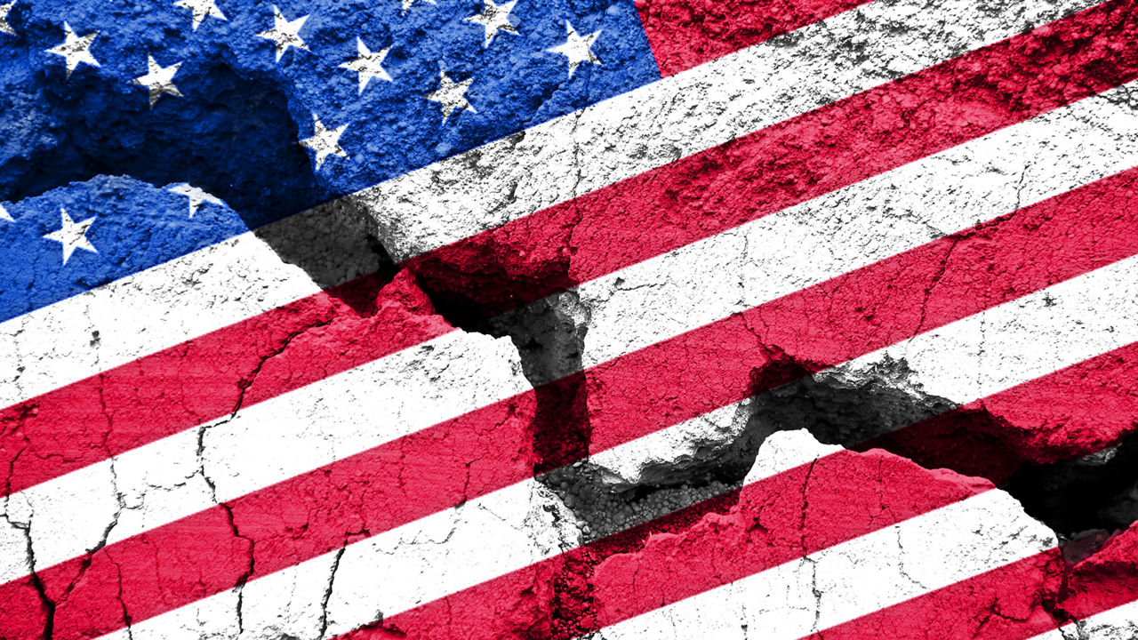 An american flag is painted on a cracked wall.