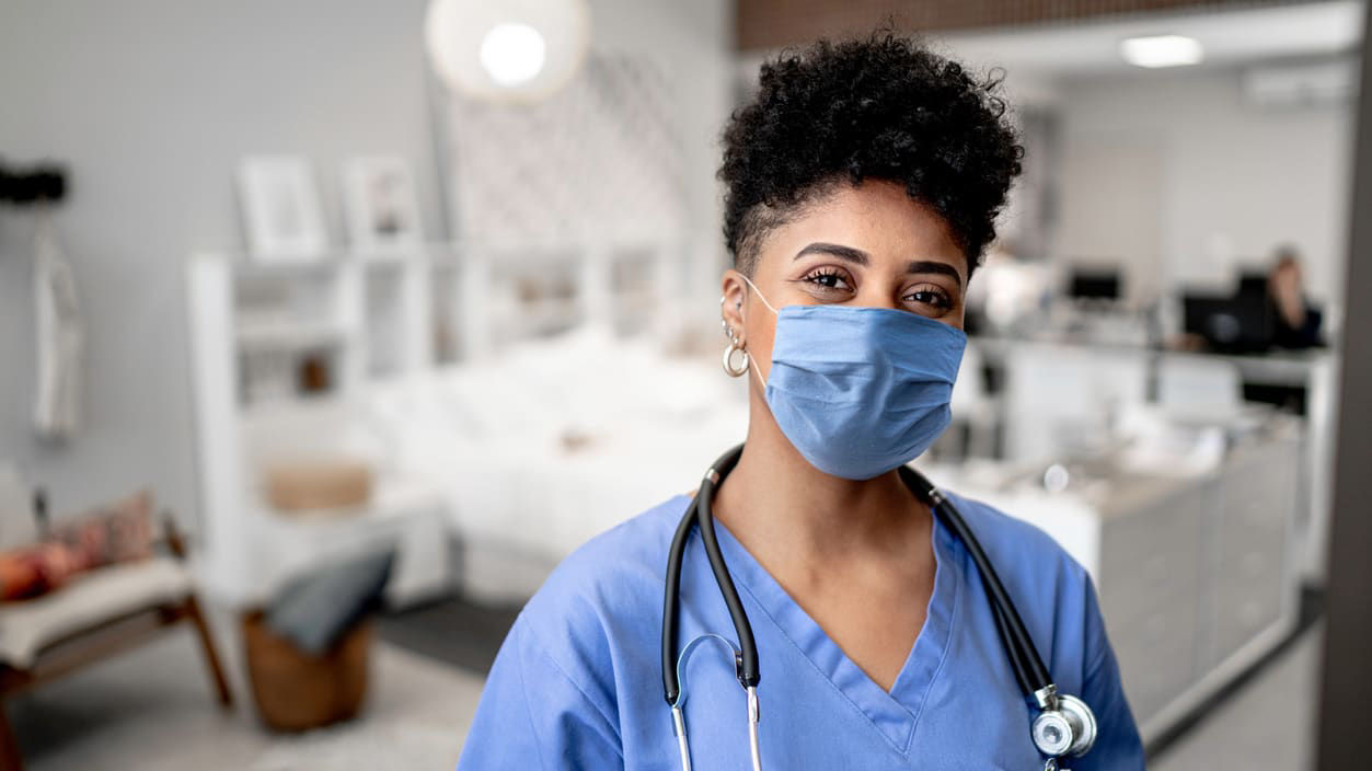 A nurse wearing a mask in an office.