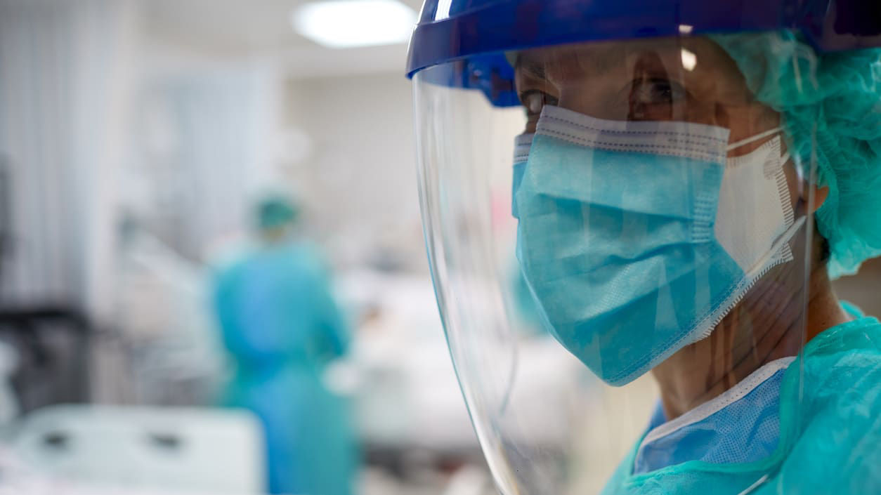 A nurse wearing a protective mask in a hospital.