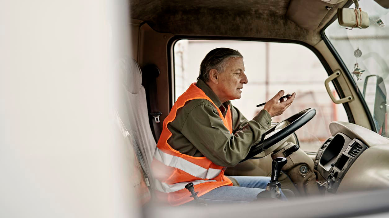 A man sitting in the driver's seat of a truck.