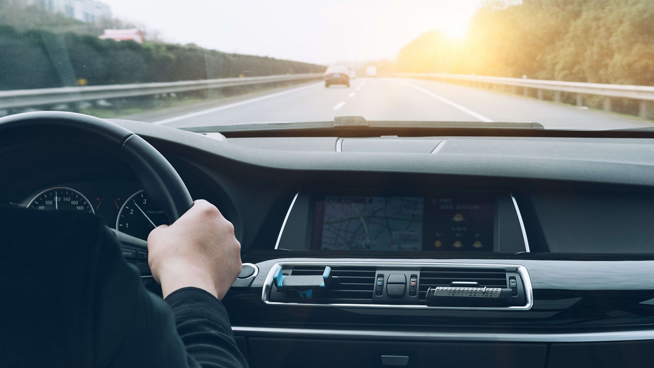 A man driving a car on a highway.