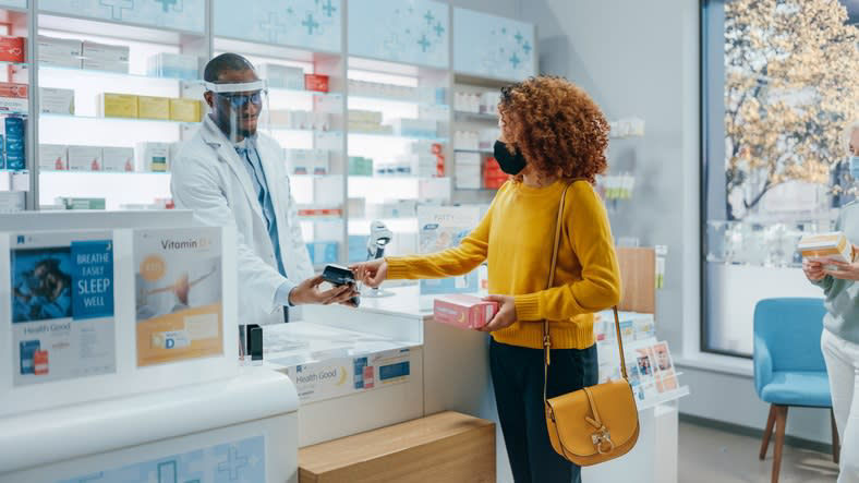 Two women are standing in a pharmacy store.