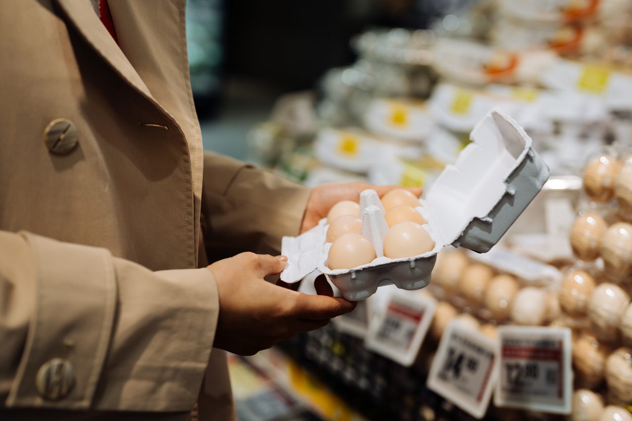 closeup of person holding eggs at grocery store