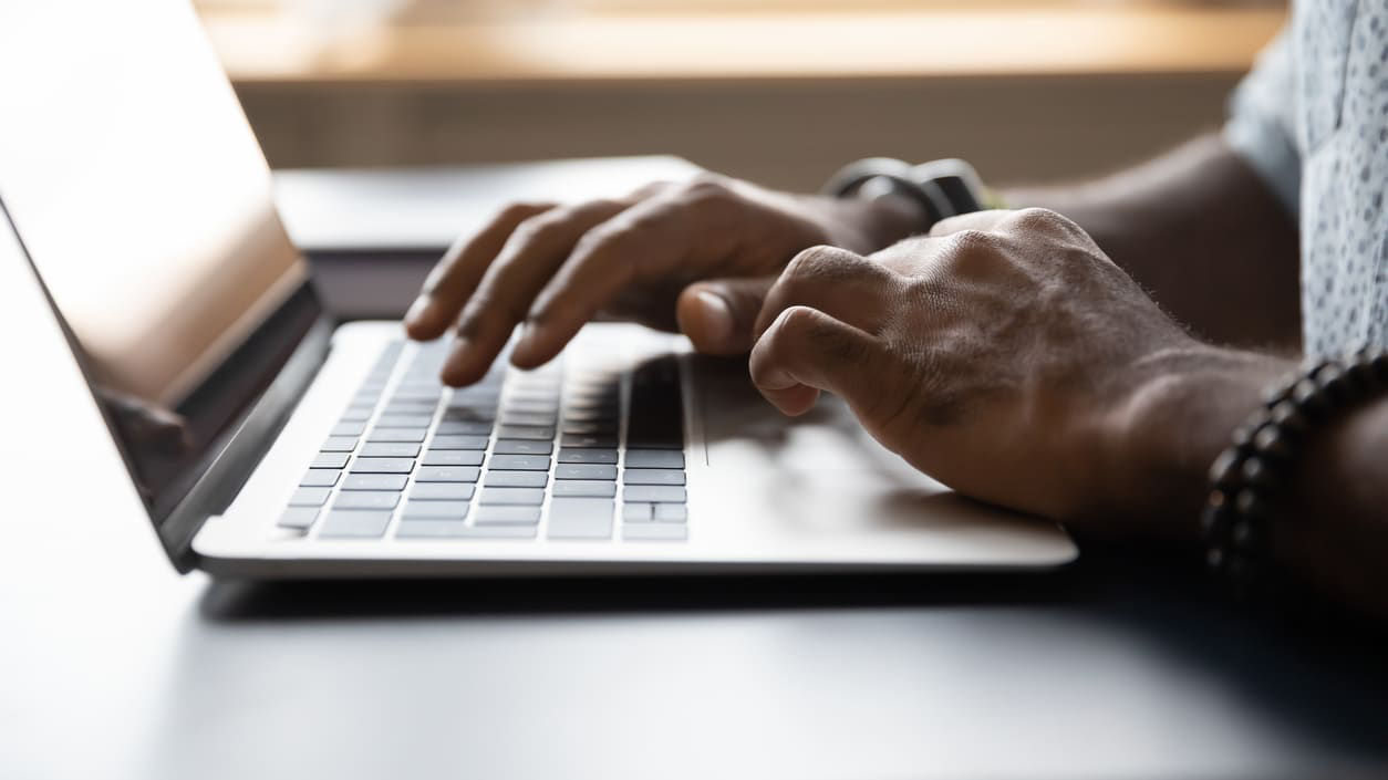 A man typing on a laptop computer.