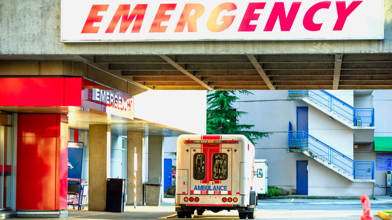 An ambulance parked in front of an emergency entrance.