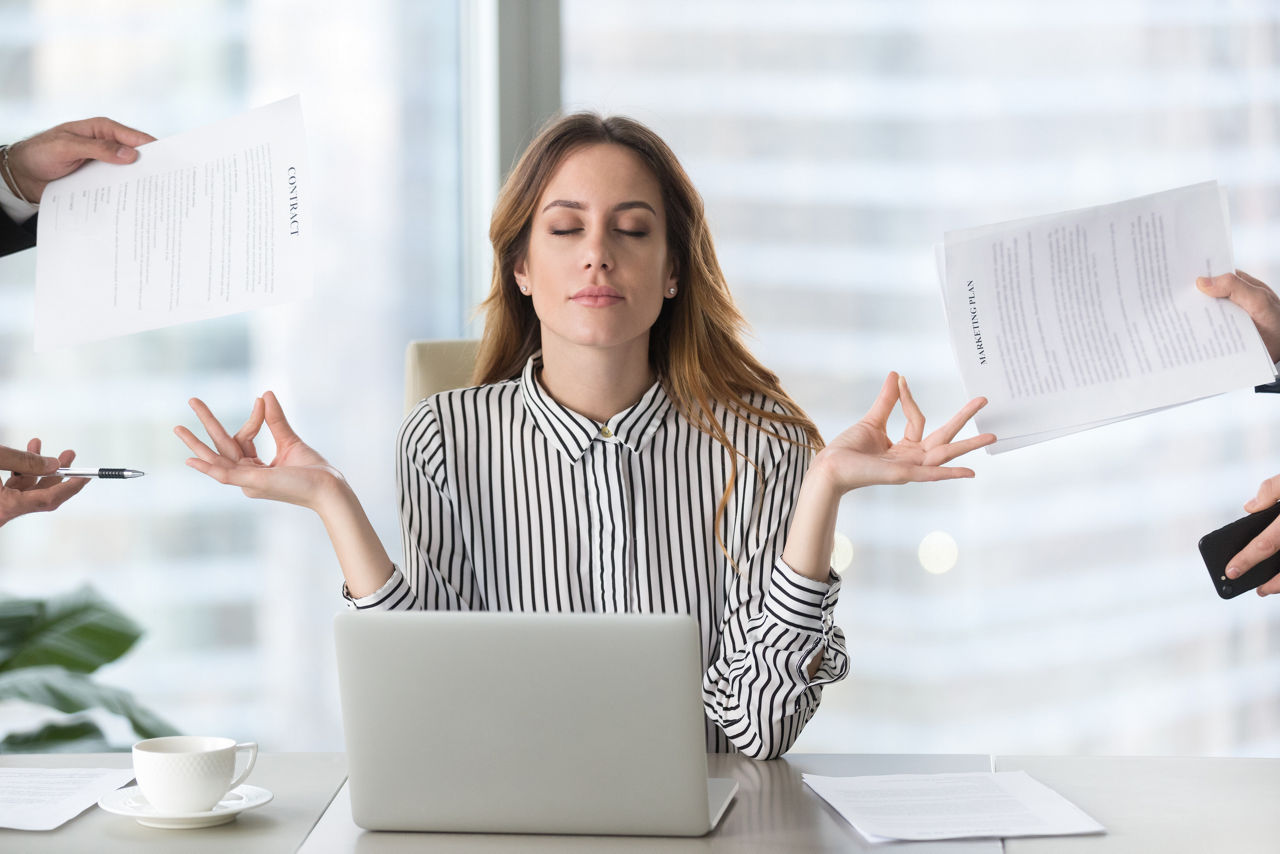 Woman meditates during a busy workday. 