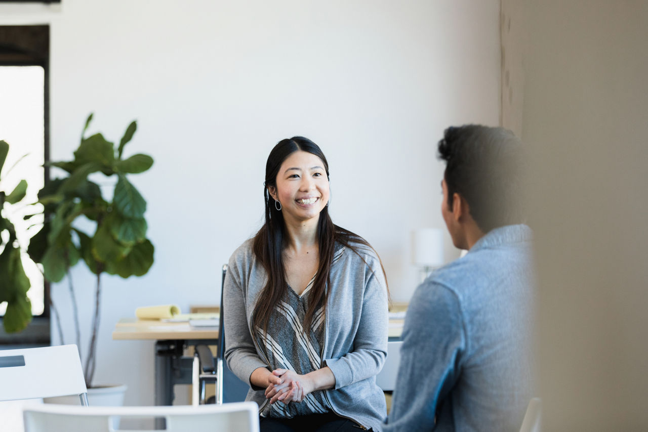 Co-workers talking, smiling in an office 