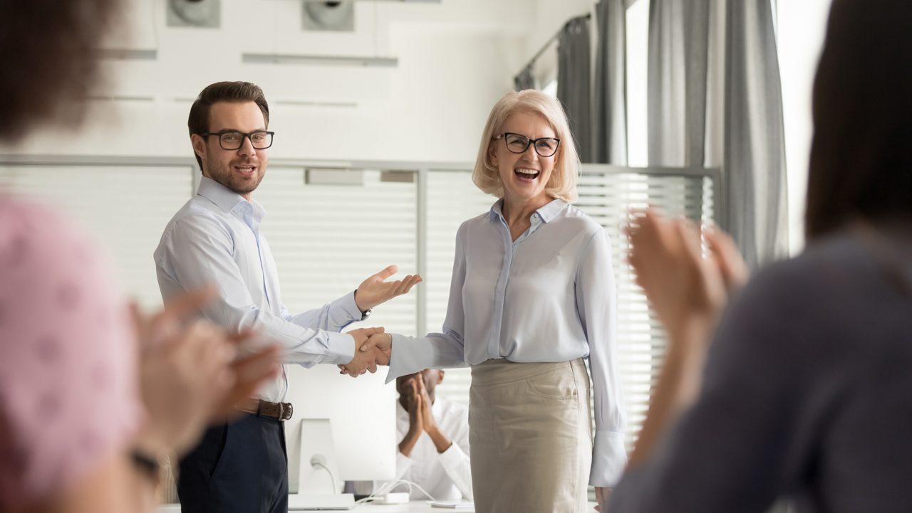 Man shakes woman's hand, in office