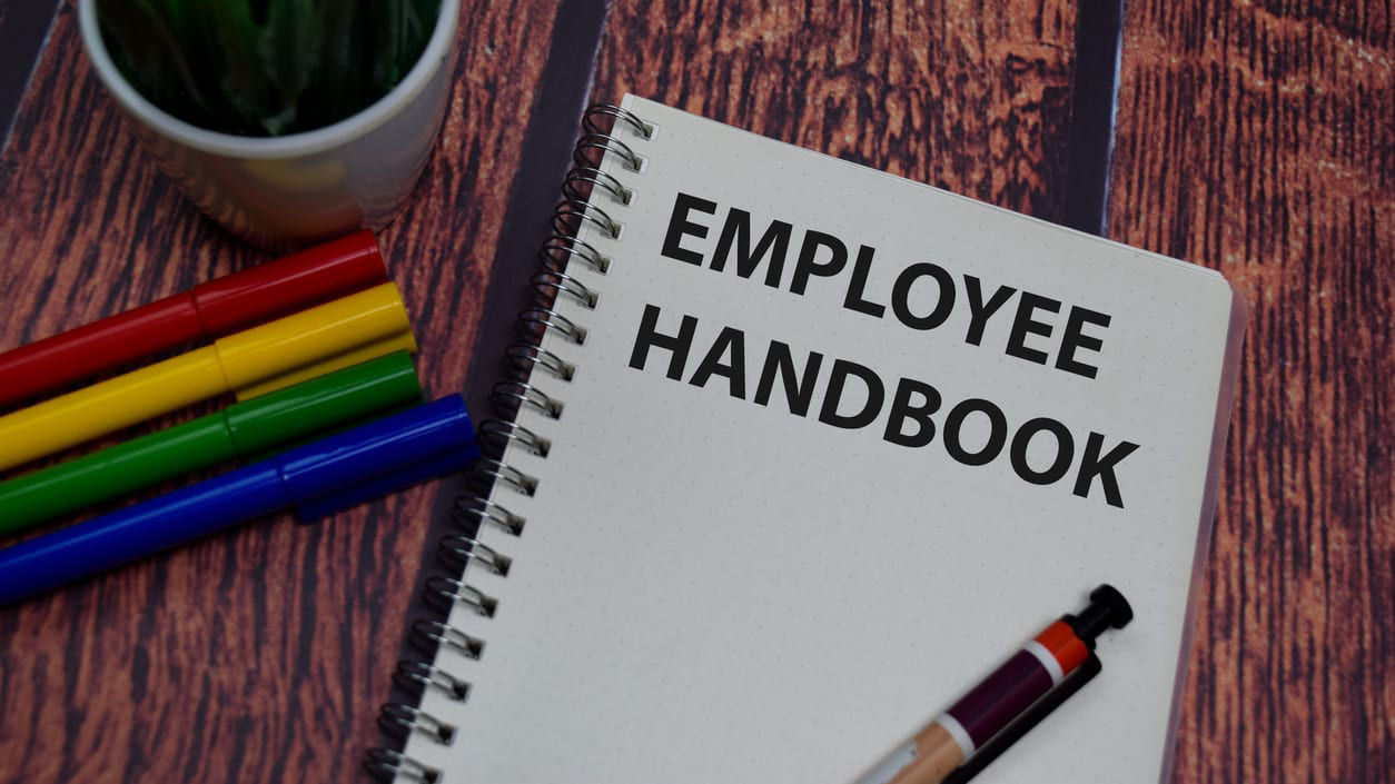 Employee handbook on a wooden table.
