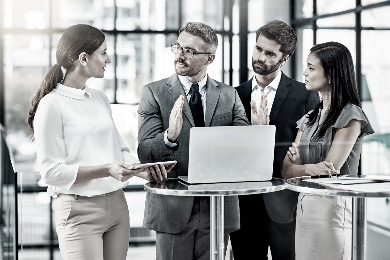 Executives Standing by Laptop