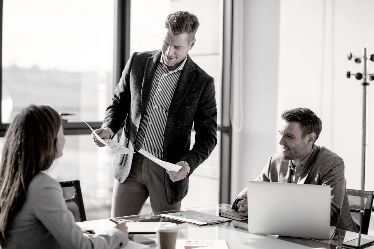 Executives Standing by Laptop