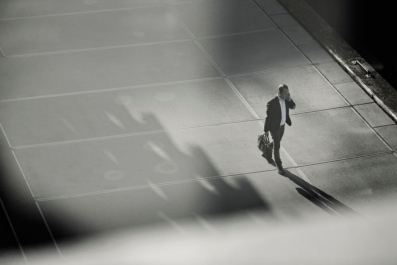 man alone talking and walking down sidewalk