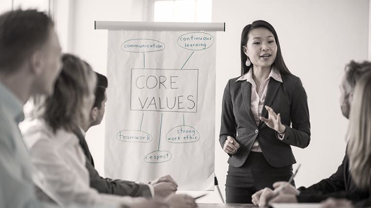 A woman is giving a presentation to a group of people.