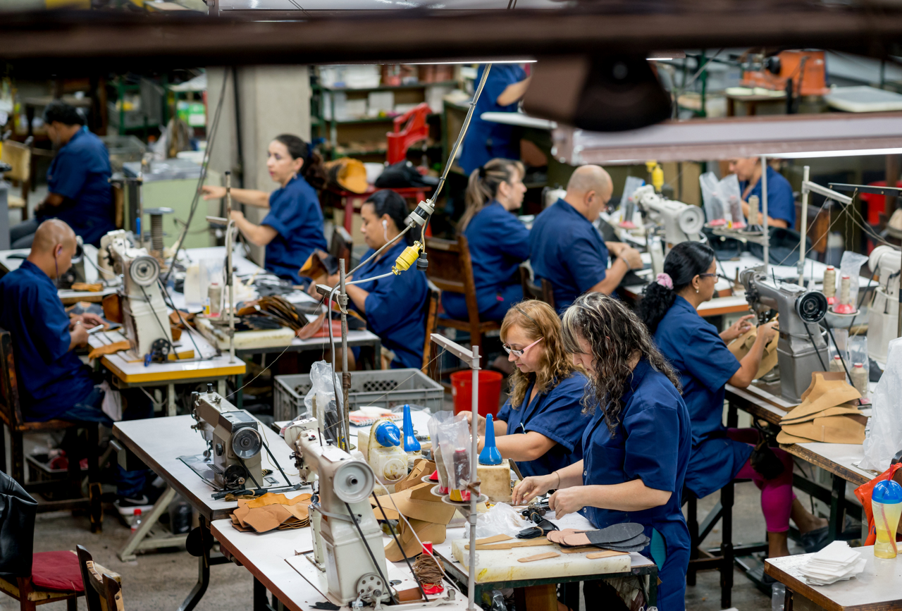Overhead view of factory floor workers sewing items