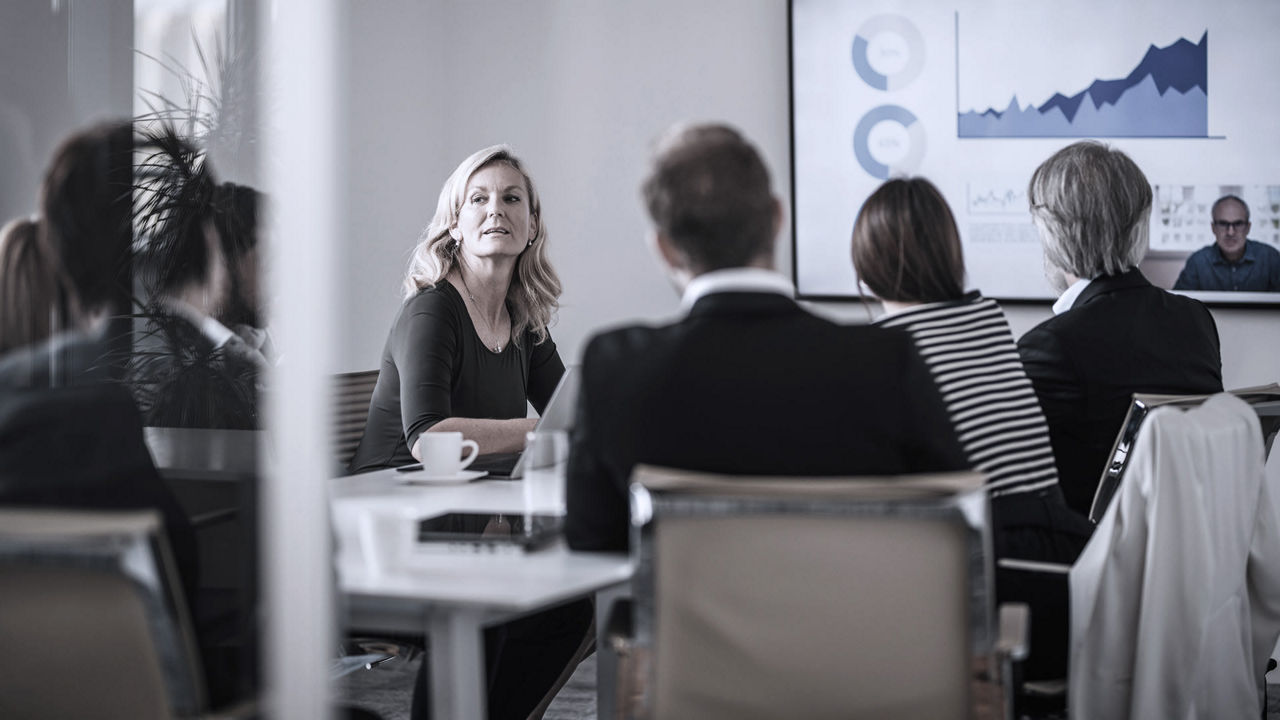 A group of people sitting around a table in a conference room.