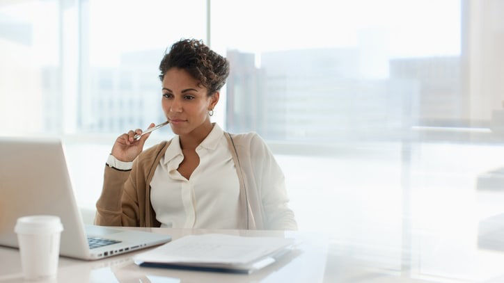 A woman sitting at a desk with a laptop in front of her.